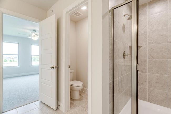 Bathroom with walk in shower, ceiling fan, toilet, and tile patterned flooring | Image 23