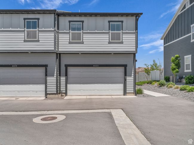 View of front of property featuring board and batten siding, a garage, and central AC unit | Image 26