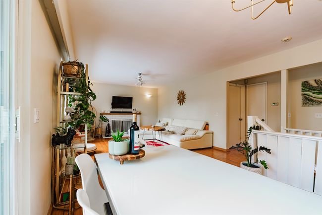 Dining space featuring a notable chandelier and wood finished floors | Image 9