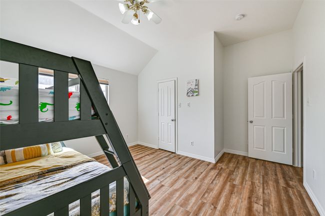 Unfurnished bedroom featuring hardwood / wood-style flooring, lofted ceiling, and ceiling fan | Image 17