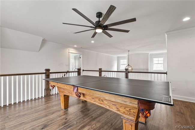 Recreation room with ceiling fan, ornamental molding, and dark wood-type flooring | Image 28