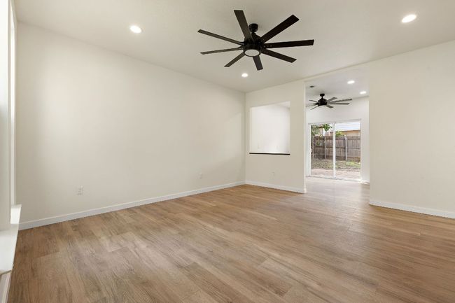 Empty room featuring light wood-style floors, ceiling fan, and recessed lighting | Image 7