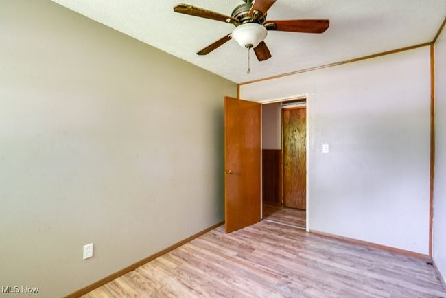 Empty room featuring wood finished floors, a ceiling fan, and baseboards | Image 21
