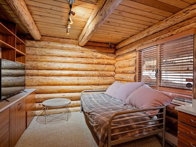 Living area featuring rustic walls, wood ceiling, and track lighting | Image 17