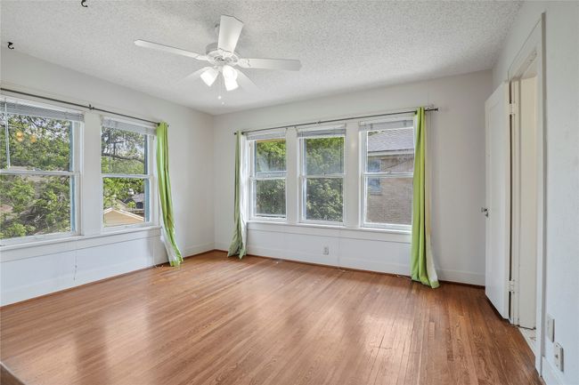 Unfurnished bedroom with light wood-style flooring, a textured ceiling, baseboards, and a ceiling fan | Image 12