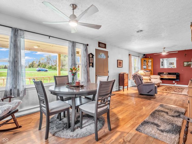 dining space with a textured ceiling, ceiling fan, and light wood-type flooring | Image 9