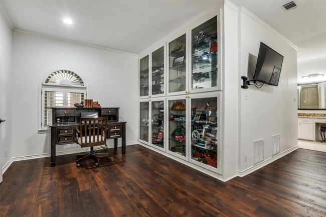 Office area in primary bedroom with glass front display cabinets | Image 16