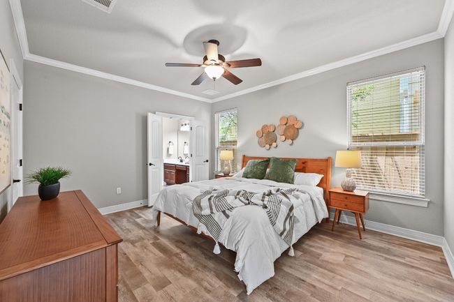 Bedroom with light wood-like finished floors, crown molding, en suite bathroom | Image 17