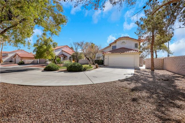 View of front facade with a tile roof, stucco siding, concrete driveway, fence, and a garage | Image 42