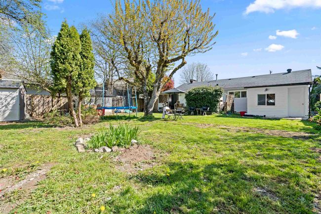 View of yard featuring an outdoor structure, a trampoline, and a shed | Image 26