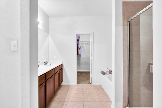 Full bath featuring a garden tub, a shower stall, a spacious closet, tile patterned flooring, and double vanity | Image 16