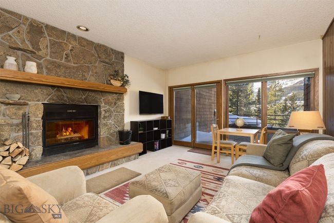 Living room with a fireplace, carpet floors, and a textured ceiling | Image 21