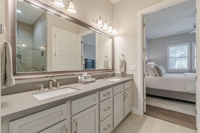 Ensuite bathroom featuring a stall shower, double vanity, and wood finished floors | Image 31
