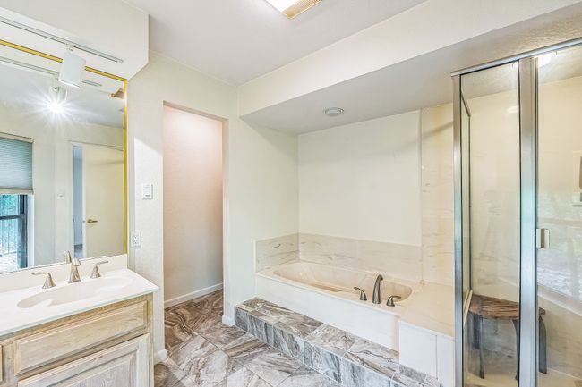 Bathroom with vanity, a shower stall, a garden tub, and marble finish floor | Image 28