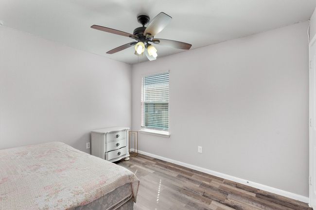 Bedroom with wood finished floors, baseboards, and a ceiling fan | Image 21