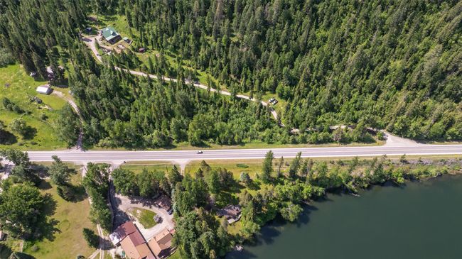 Aerial overview of property's location with a nearby body of water and a heavily wooded area | Image 76