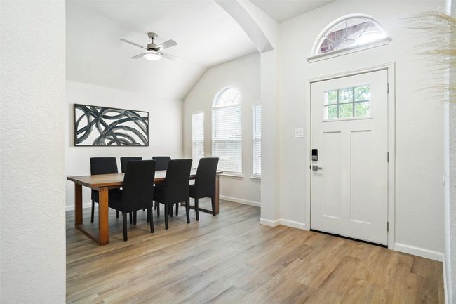 Foyer featuring arched walkways, light wood-type flooring, lofted ceiling, a ceiling fan, and baseboards | Image 11