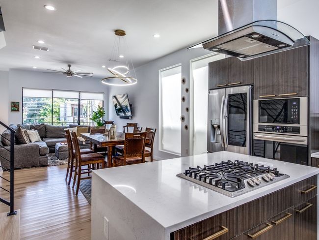 Kitchen with appliances with stainless steel finishes, range hood, modern cabinets, recessed lighting, and a ceiling fan | Image 13