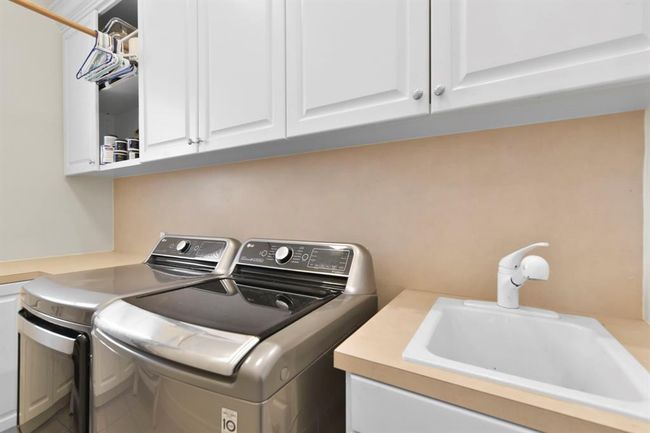 Convenient first-floor laundry room with extra sink and ample storage. | Image 27