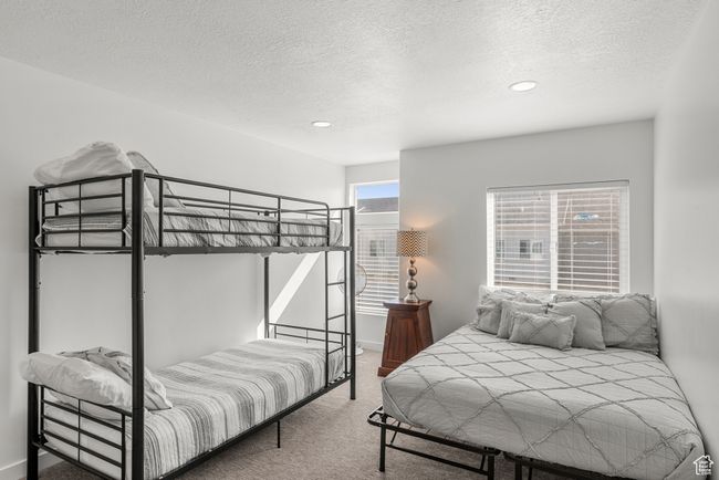 Bedroom with baseboards, carpet floors, and a textured ceiling | Image 27