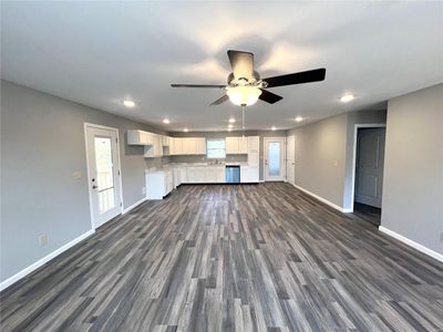 Unfurnished living room with sink, ceiling fan, and dark hardwood / wood-style flooring | Image 2