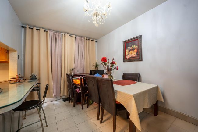 Dining space featuring a chandelier and light tile patterned floors | Image 8