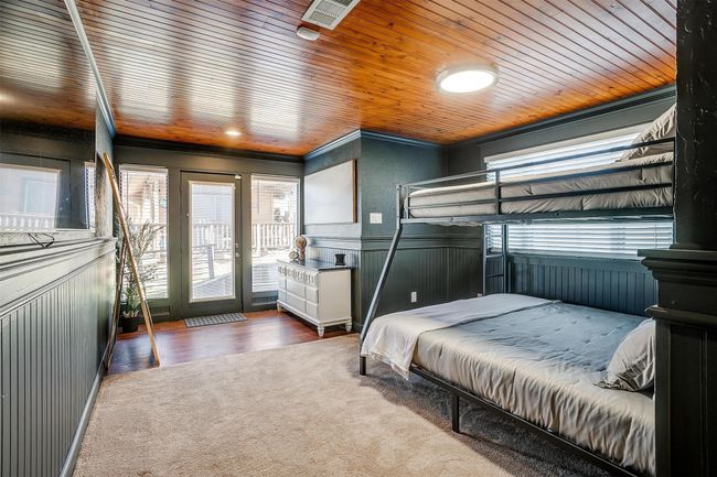 Bedroom featuring access to outside, wainscoting, ornamental molding, and wood finished floors | Image 26