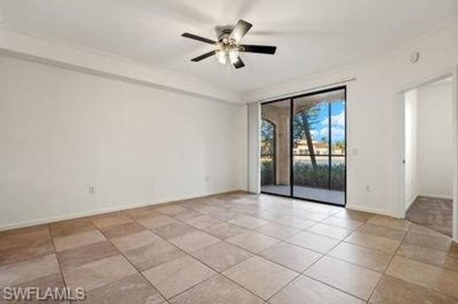 Empty room with light tile patterned flooring, baseboards, and a ceiling fan | Image 5