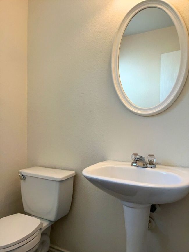 Bathroom featuring toilet and a textured wall | Image 11