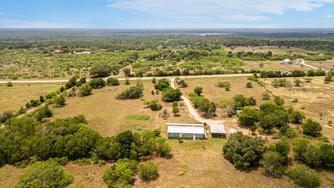 Aerial view of sparsely populated area featuring a heavily wooded area | Image 11