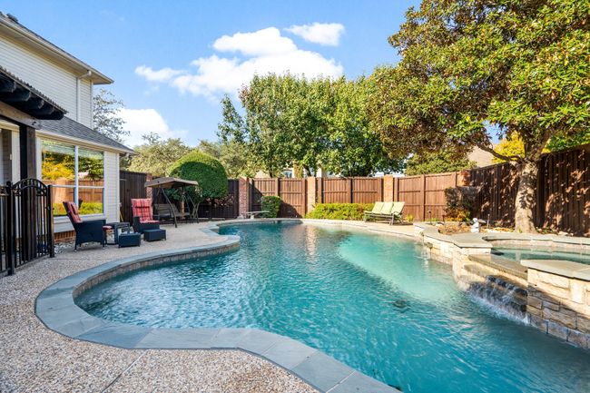 View of swimming pool featuring a fenced in pool, a patio area, a fenced backyard, and an in ground hot tub | Image 30