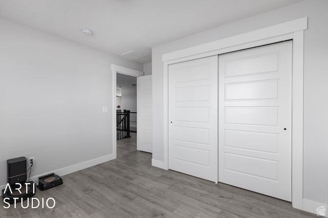 Unfurnished bedroom featuring wood finished floors, baseboards, and a closet | Image 25