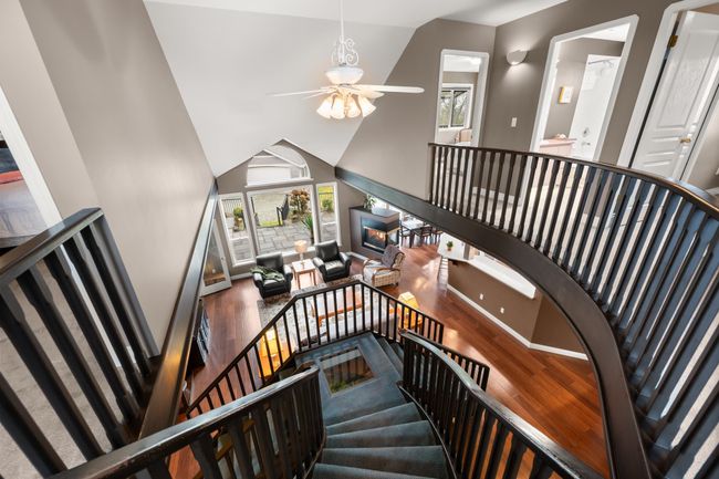 Staircase with high vaulted ceiling, wood finished floors, and a ceiling fan | Image 19