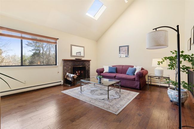 Living room with cathedral ceiling, skylight and wood-burning fireplace | Image 8