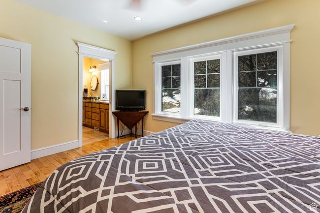 Bedroom with baseboards, recessed lighting, light wood-style floors, and ensuite bath | Image 16
