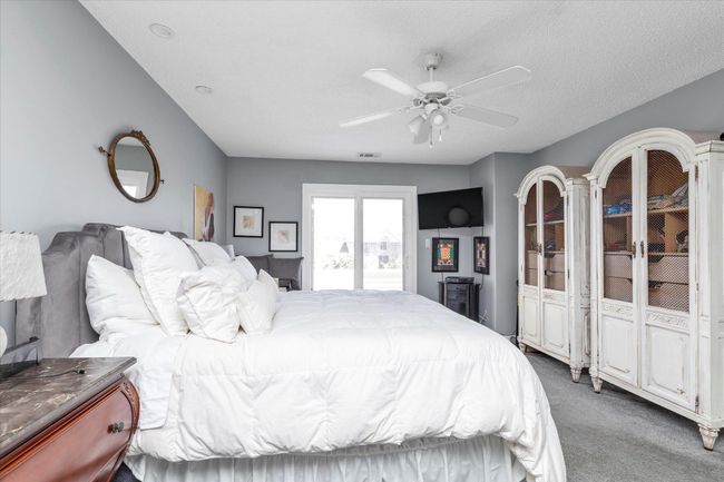 Carpeted bedroom featuring a textured ceiling, a ceiling fan, and visible vents | Image 10