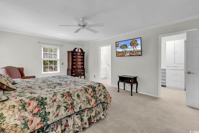 Bedroom with crown molding, light carpet, a ceiling fan, and ensuite bath | Image 9