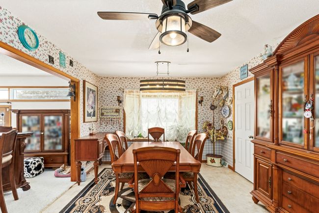 Dining space with ceiling fan and wallpapered walls | Image 41