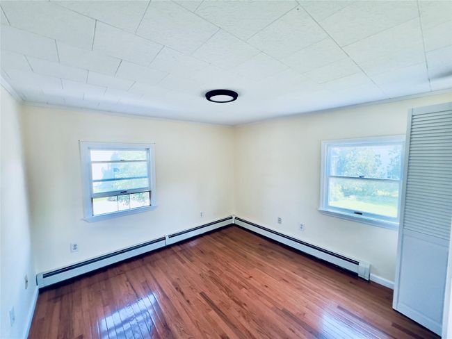 Unfurnished room with a baseboard radiator, wood finished floors, and crown molding | Image 14