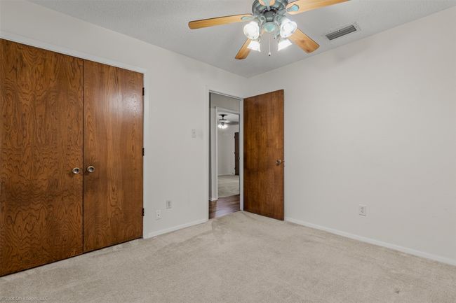 Unfurnished bedroom featuring carpet flooring, baseboards, a closet, and a ceiling fan | Image 15