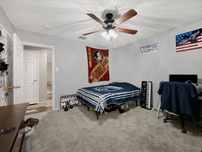 Carpeted bedroom with ceiling fan and a textured ceiling | Image 20