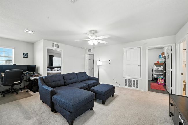 Living area featuring carpet flooring, a desk, and a ceiling fan | Image 17