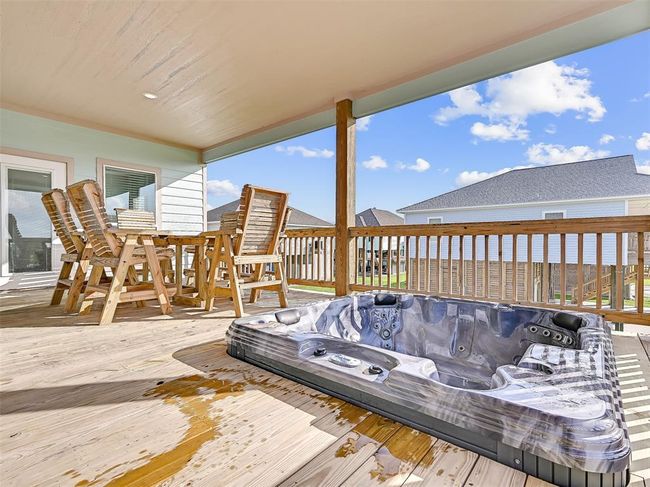 Unwind in the private hot tub on the covered deck—perfect for relaxing after a day at the beach or enjoying a peaceful evening under the stars. | Image 5