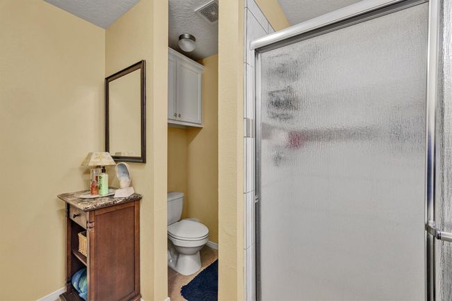 The bathroom features an oversize shower with frosted glass privacy door. | Image 18