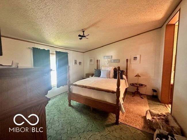 carpeted bedroom with vaulted ceiling and a textured ceiling | Image 11