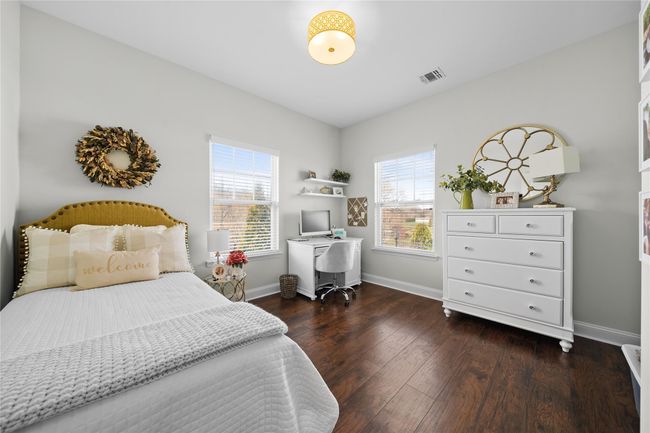 Bedroom with dark wood finished floors, baseboards, and visible vents | Image 15