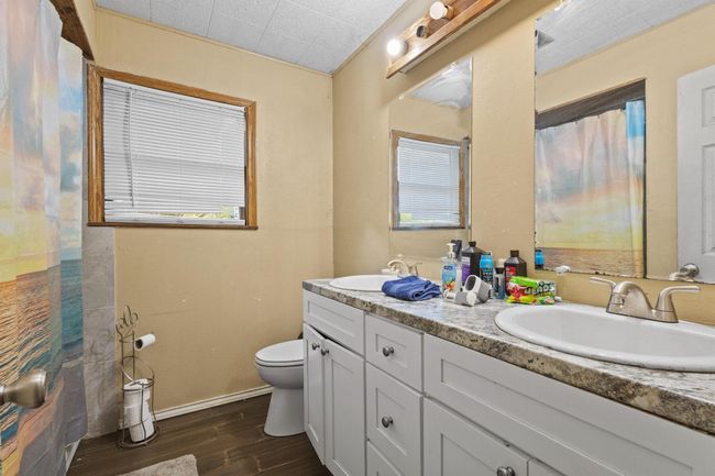 Bathroom with double vanity, wood finished floors, and healthy amount of natural light | Image 9