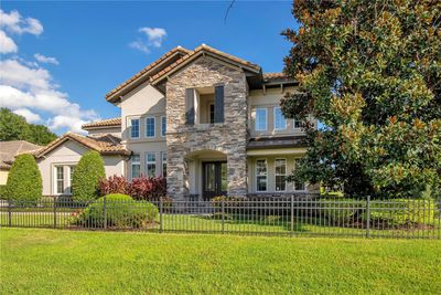 Welcome to your Mediterranean dream home! This stunning estate showcases timeless architecture, stone accents, and a tiled roof, all on nearly an acre of beautifully landscaped land. | Image 1