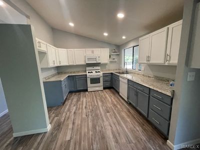 Kitchen has vaulted ceilings, new cabinets, counters, flooring and lighting! | Image 3