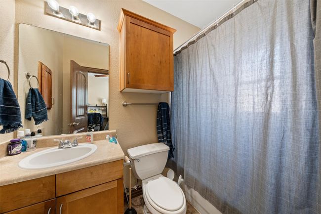 Full bathroom featuring vanity, a textured wall, and a shower with shower curtain | Image 15